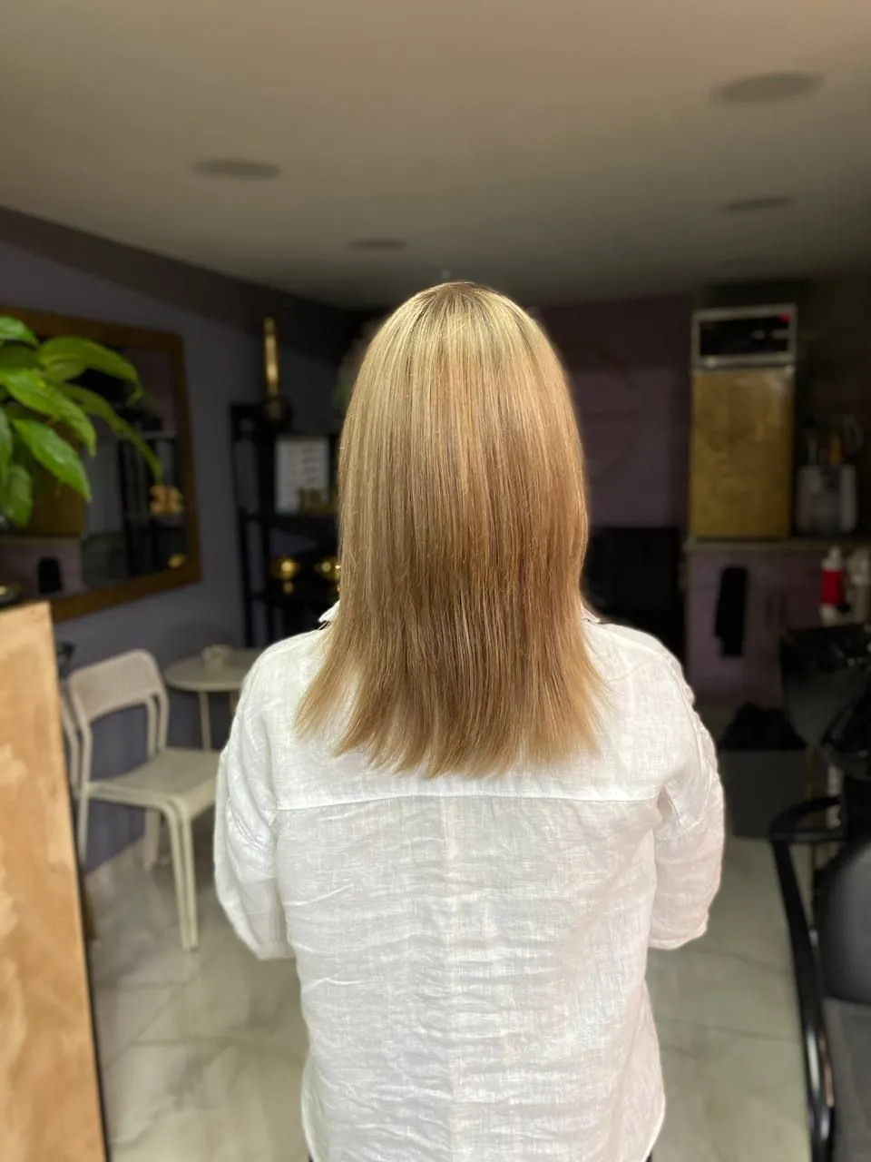 Warm honey blonde, shoulder length, seen from behind