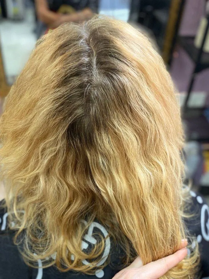 The same curls before the fix: yellow, patchy, with dark roots