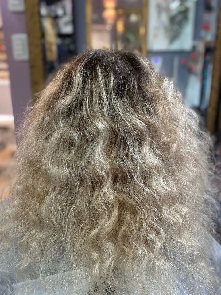 The same curls before coloring: light blonde with dark roots
